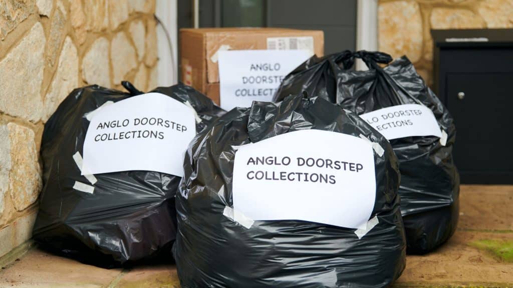 Bag of clothes on doorstep, labelled for Anglo doorstep collections.